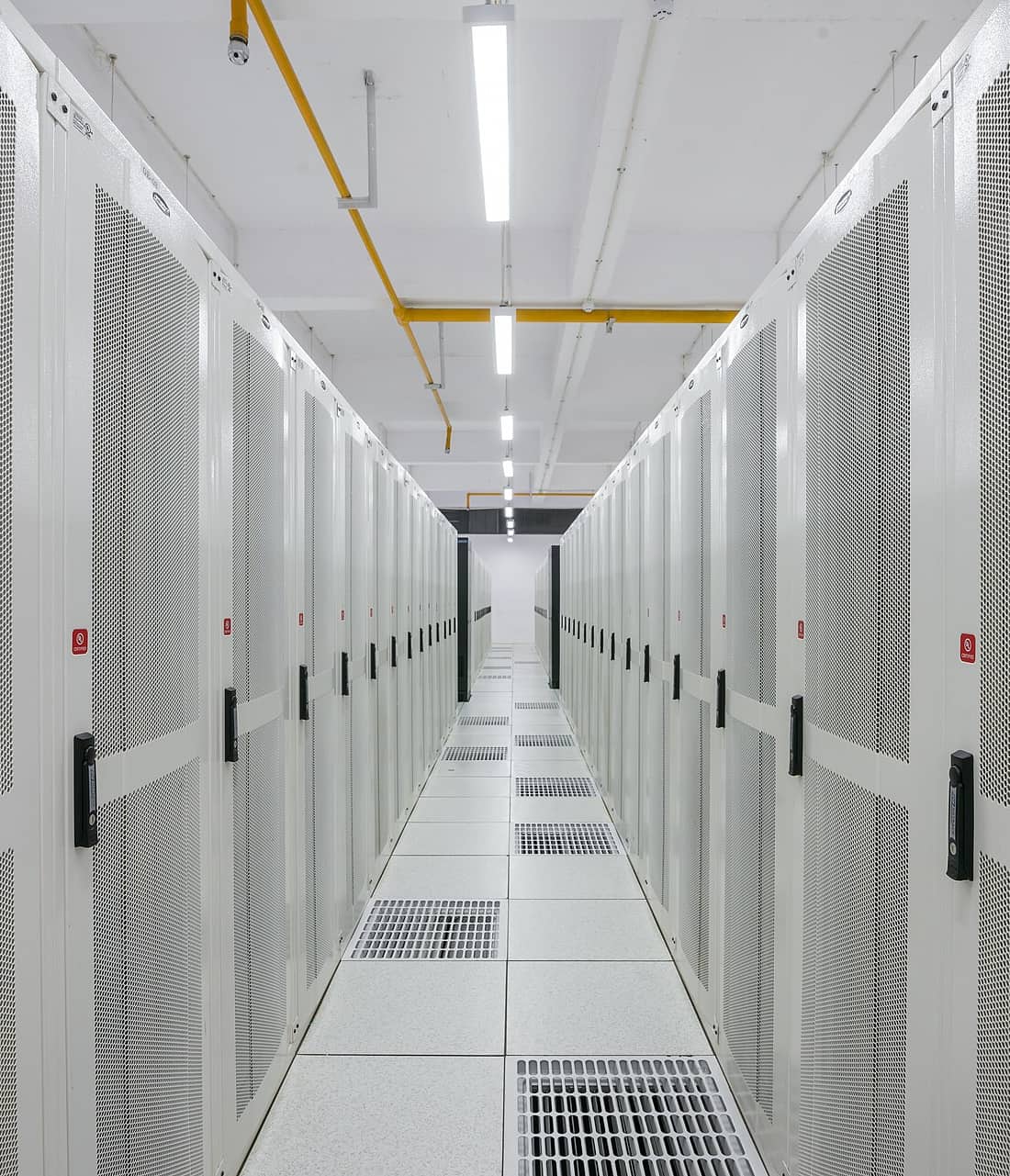 A long aisle between white server racks in a data center in Amravati, India